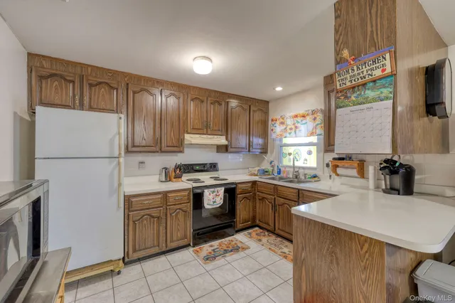 a kitchen with a sink a stove top oven and cabinetry