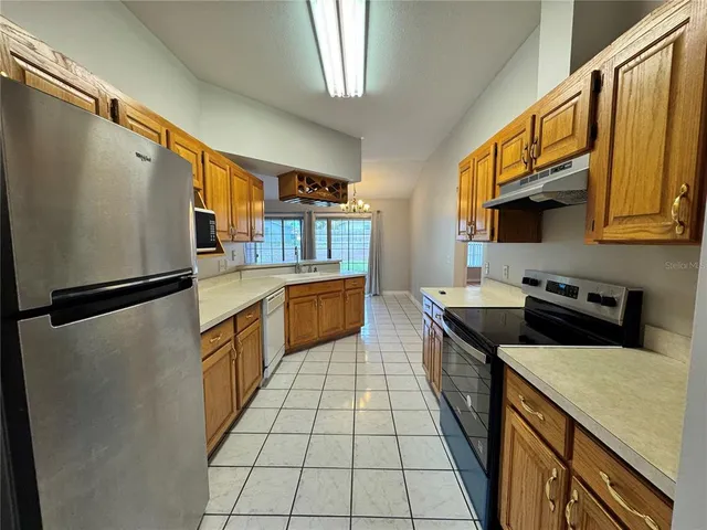 a large kitchen with a stove a sink dishwasher a refrigerator and a microwave oven