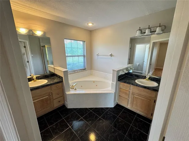 a bathroom with a granite countertop toilet a sink and a bathtub