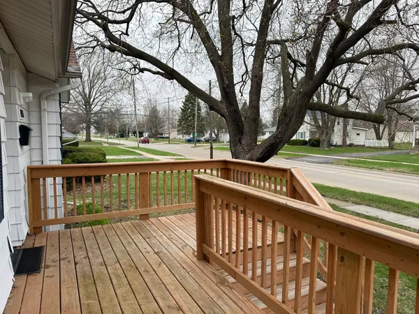 a view of street with wooden deck and trees
