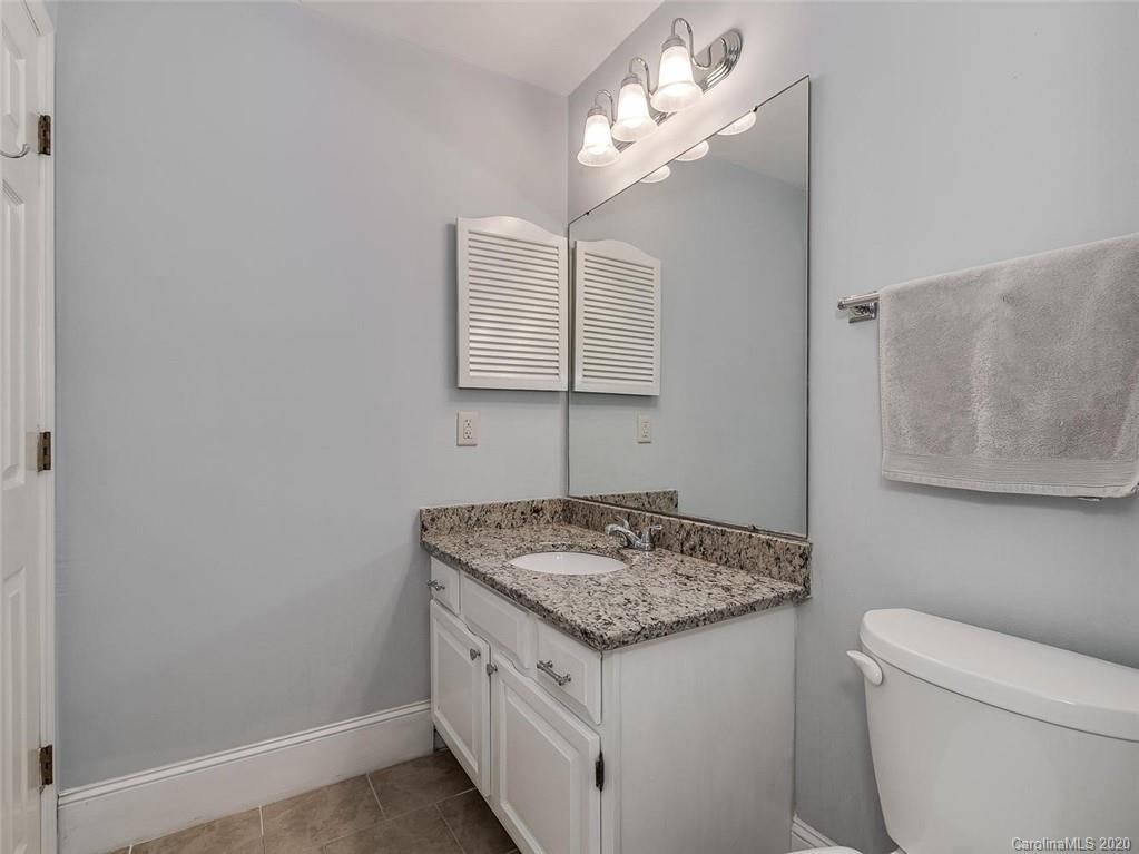 222 Queens Road, Unit 54 Charlotte, NC 28204 - Photo 14 of 18 a bathroom with a granite countertop sink and a mirror