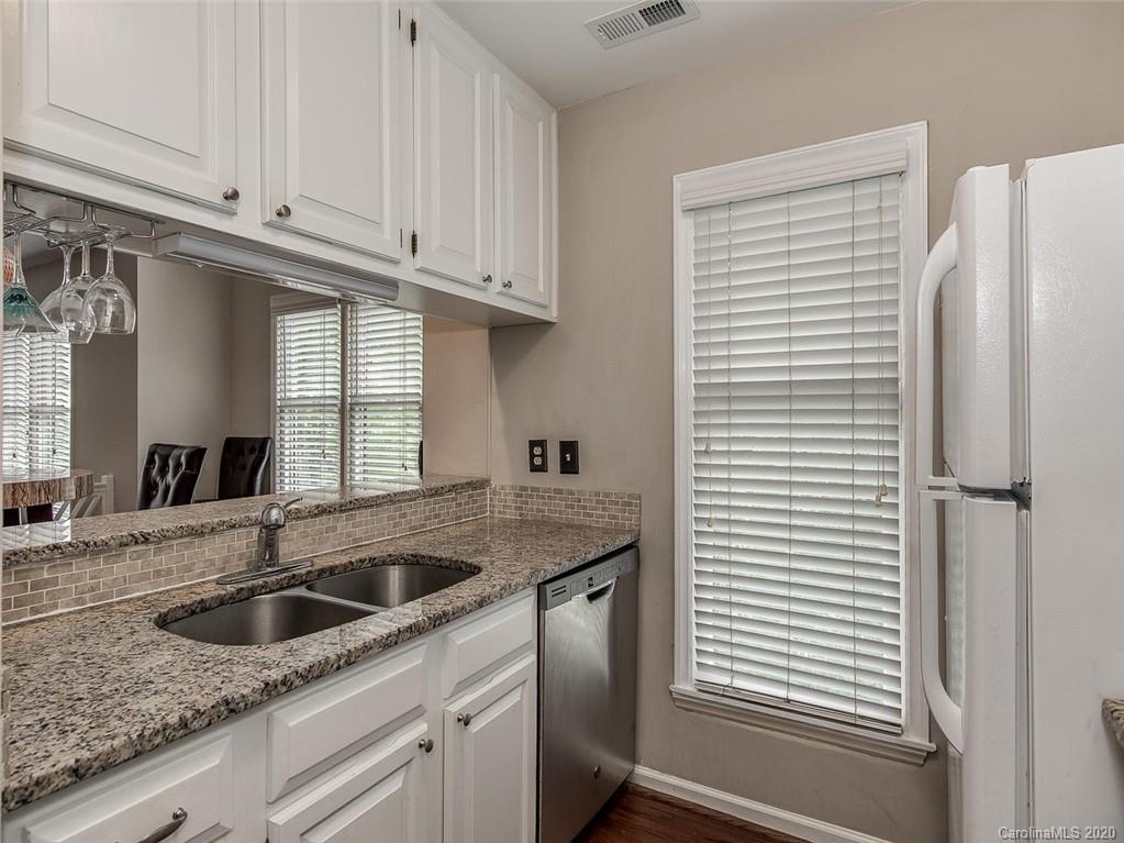 222 Queens Road, Unit 54 Charlotte, NC 28204 - Photo 3 of 18 a kitchen with stainless steel appliances granite countertop a sink a refrigerator and window