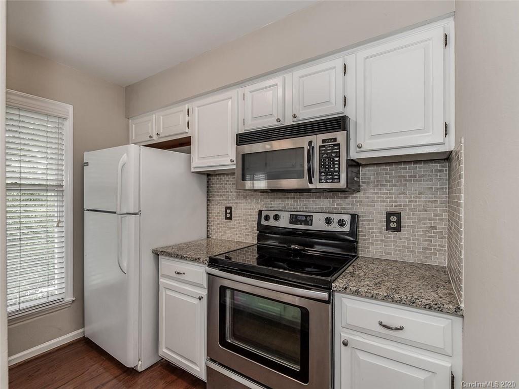 222 Queens Road, Unit 54 Charlotte, NC 28204 - Photo 4 of 18 a kitchen with cabinets stainless steel appliances and a wooden floor