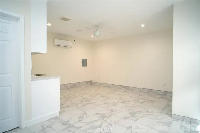 an empty room with a ceiling fan and bathroom