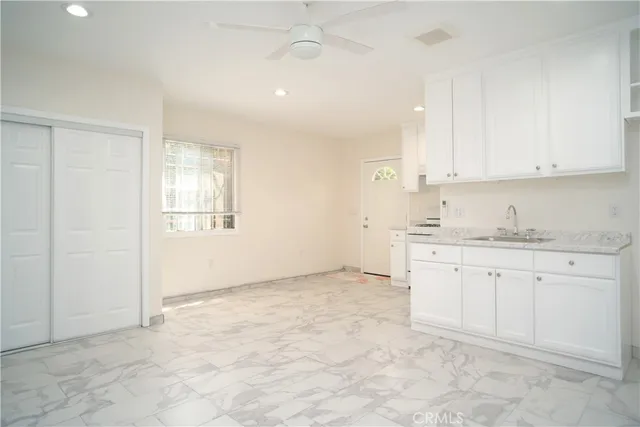 a view of kitchen with granite countertop cabinets and sink
