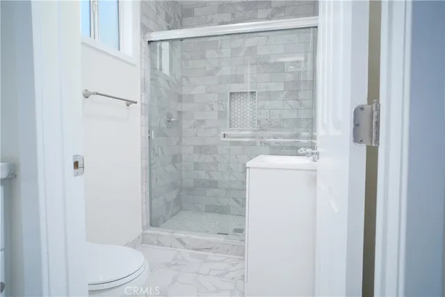 a bathroom with a shower a toilet and sink