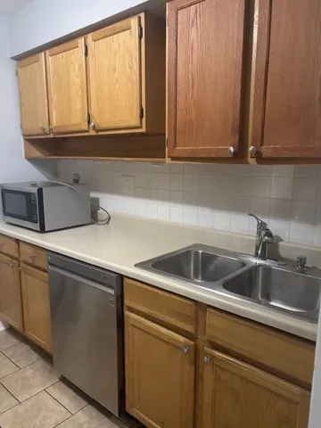 a kitchen with stainless steel appliances granite countertop white cabinets and a sink