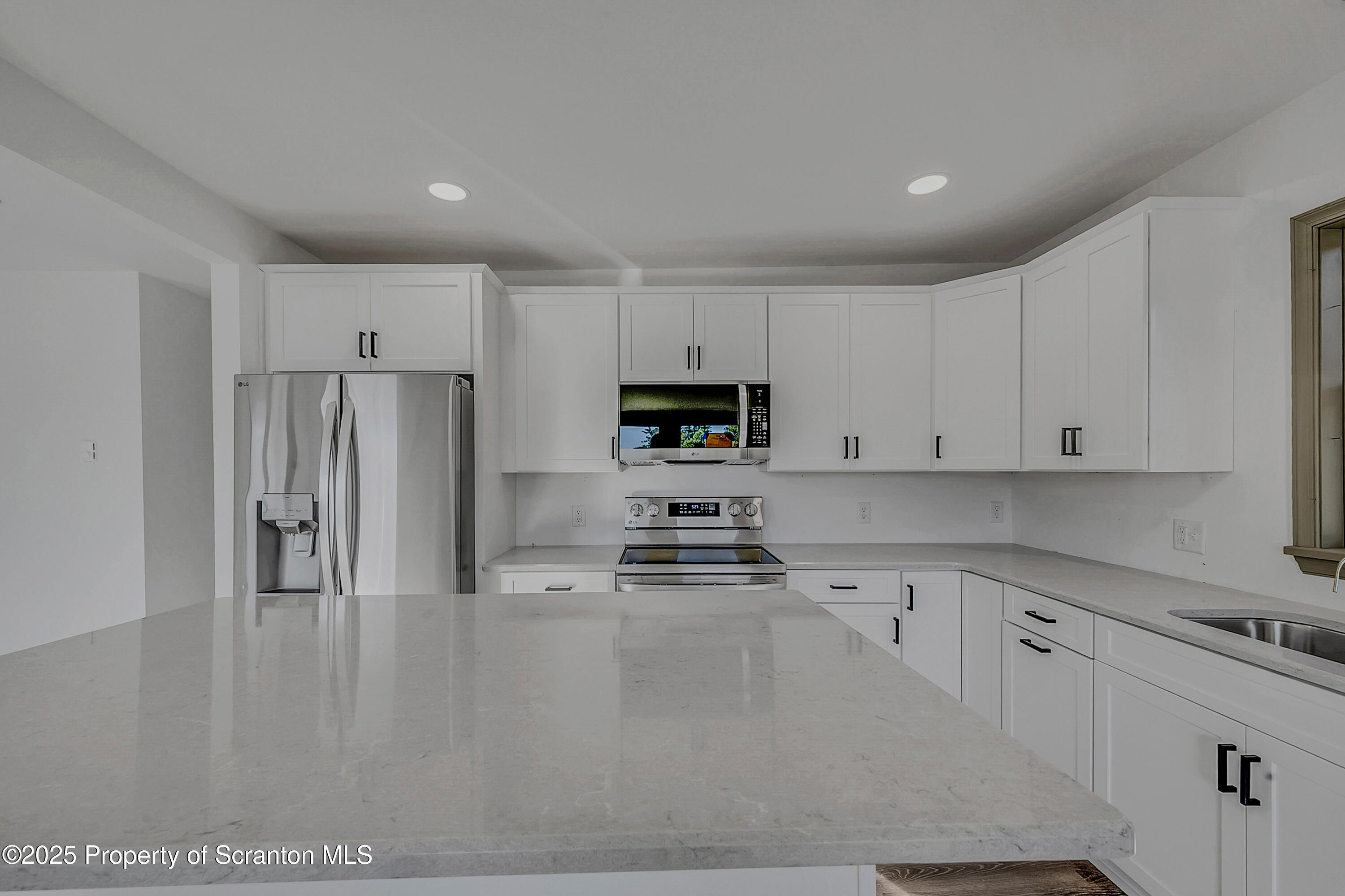 1262 Lake Road Lake Winola, PA 18419 - Photo 19 of 33 a kitchen with granite countertop a refrigerator sink and white cabinets