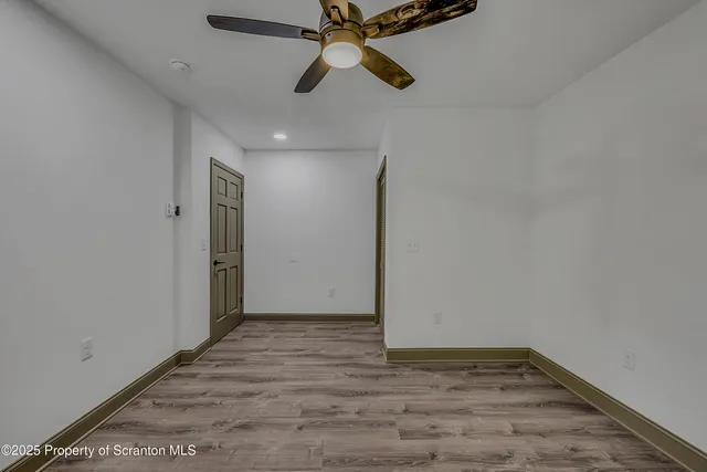 an empty room with fan and windows