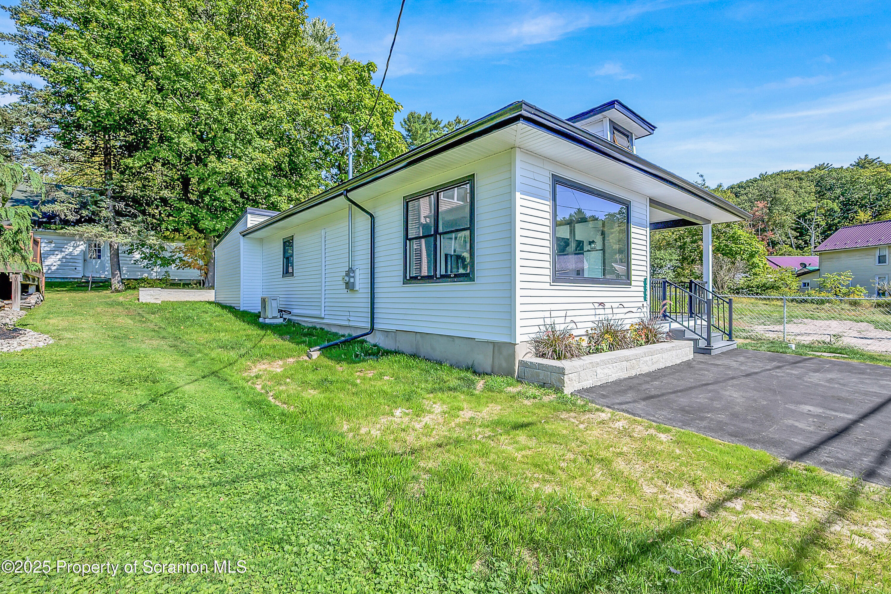 1262 Lake Road Lake Winola, PA 18419 - Photo 3 of 33 a backyard of a house with wooden fence and large trees