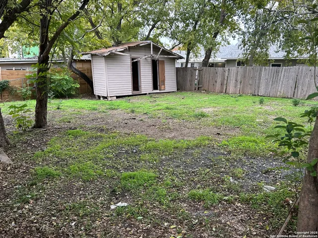 a view of a house with yard and large trees