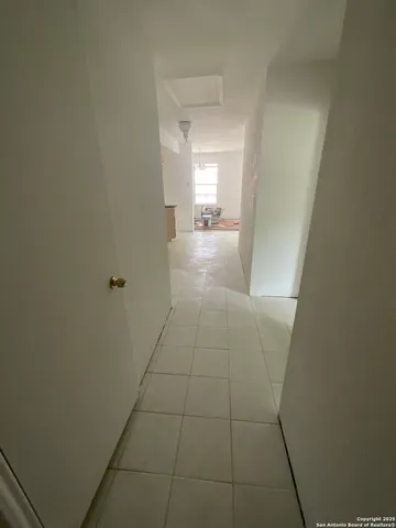 a view of hallway with bathroom and a sink