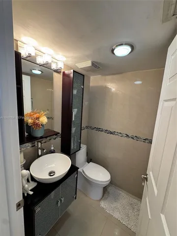 a bathroom with a sink toilet mirror and shower
