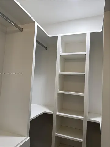 a view of walk in closet with empty racks