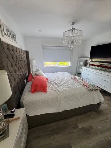 a bedroom with a bed window and a flat screen tv