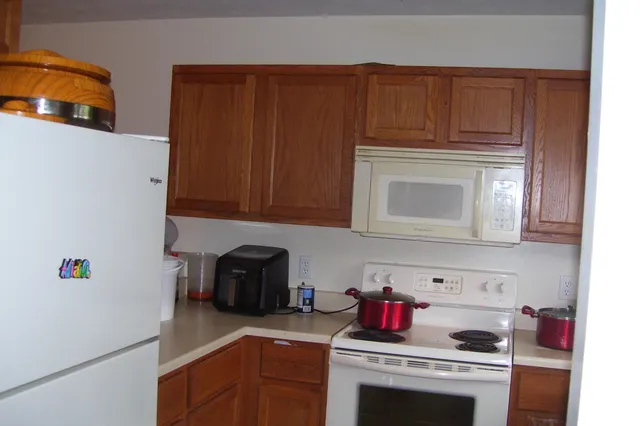 a kitchen with stainless steel appliances granite countertop a refrigerator and a stove