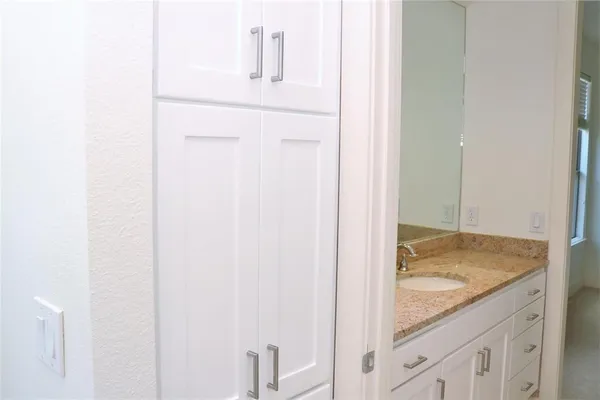 a bathroom with a granite countertop sink and a mirror