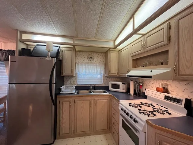 a kitchen with stainless steel appliances a stove a refrigerator and cabinets