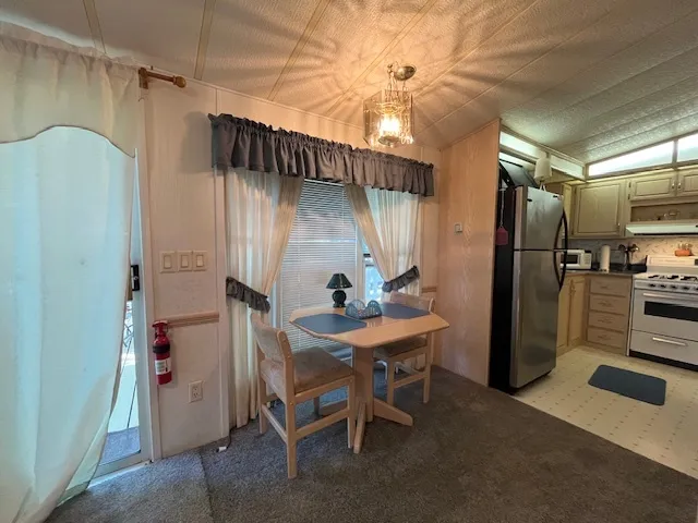 a kitchen with stainless steel appliances kitchen island granite countertop a refrigerator and a stove top oven