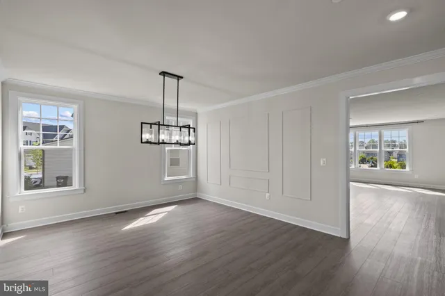a view of empty room with wooden floor and windows