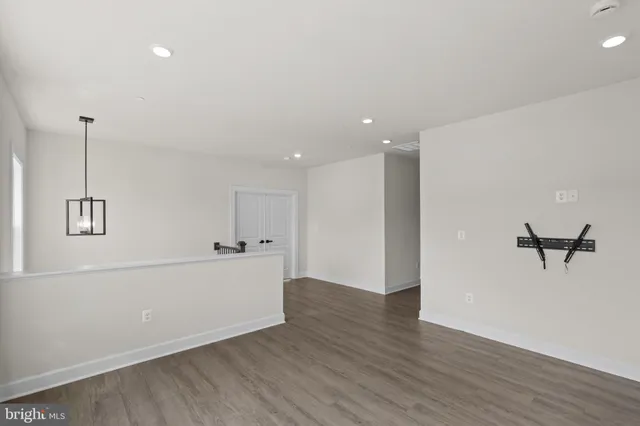 a view of a hallway with wooden floor and windows