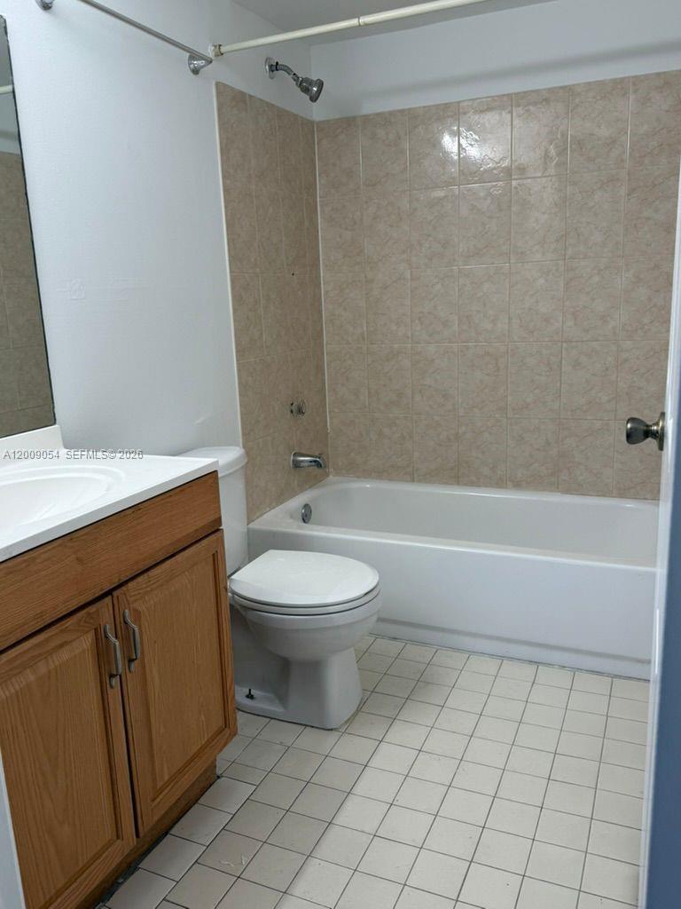 6955 Northwest 186th Street, Unit F209 Hialeah, FL 33015 - Photo 11 of 14 a bathroom with a sink a toilet and shower