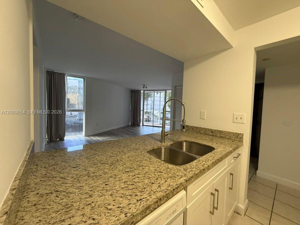 6955 Northwest 186th Street, Unit F209 Hialeah, FL 33015 - Photo 4 of 14 a kitchen with a sink and granite top
