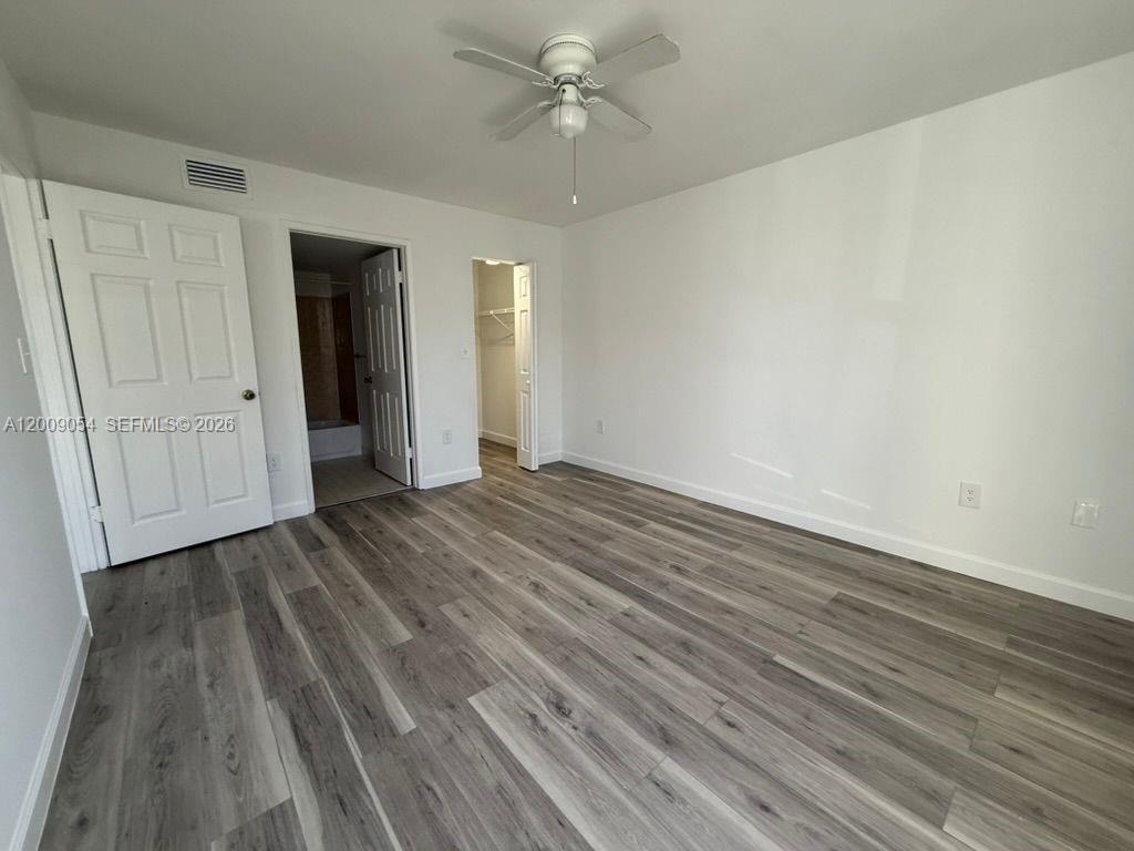 6955 Northwest 186th Street, Unit F209 Hialeah, FL 33015 - Photo 7 of 14 wooden floor in an empty room with a window