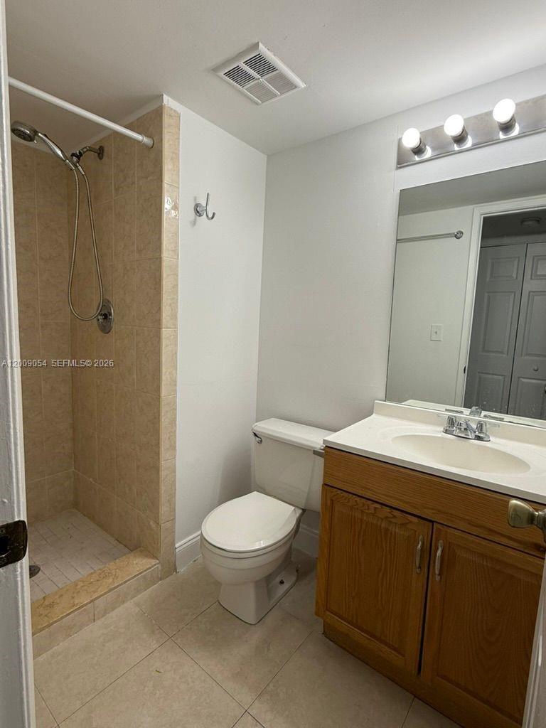 6955 Northwest 186th Street, Unit F209 Hialeah, FL 33015 - Photo 9 of 14 a bathroom with a sink toilet and shower