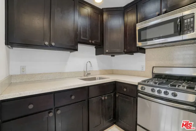 a kitchen with stainless steel appliances a sink stove and cabinets