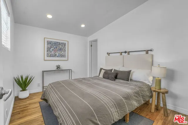 a bedroom with a bed and a potted plant