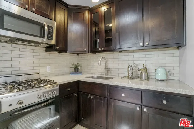 a kitchen with stainless steel appliances granite countertop a sink stove and cabinets
