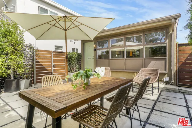 a patio with a table and chairs under an umbrella