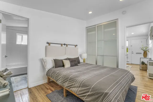a bedroom with a bed and wooden floor
