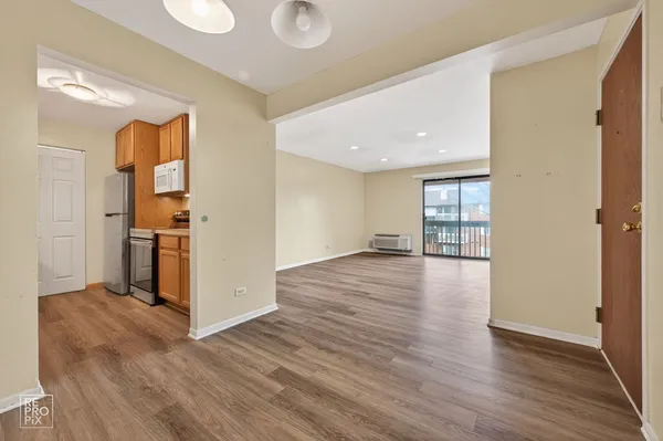 a view of a big room with wooden floor and windows