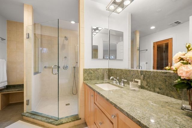 a bathroom with a granite countertop sink mirror and shower