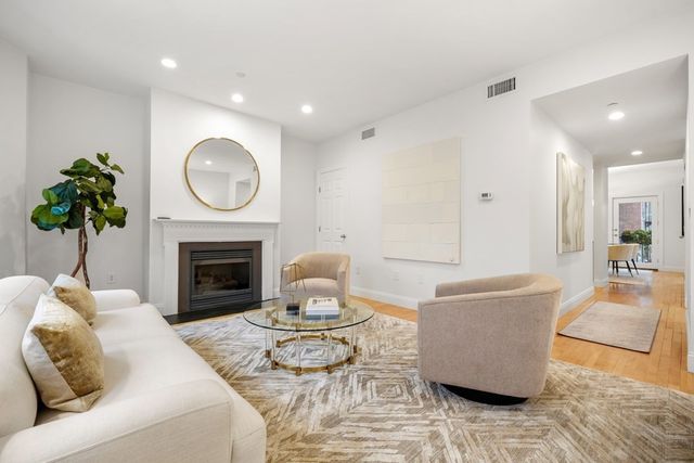 a living room with furniture a fireplace and a potted plant