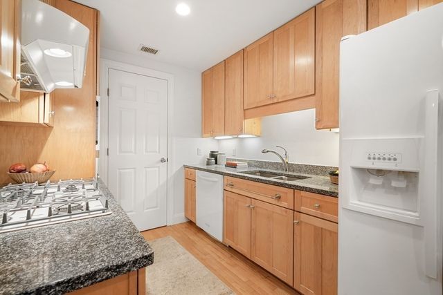 a kitchen with granite countertop a sink stove and cabinets