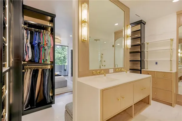 a view of walk in closet with clothes and shoes
