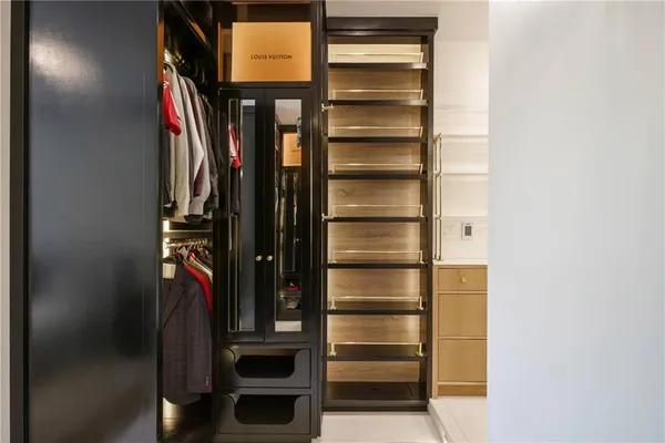 a view of walk in closet with clothes and shoes