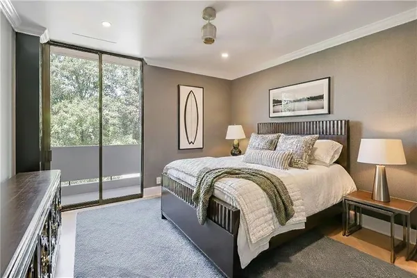 a spacious bedroom with a bed and wooden floor
