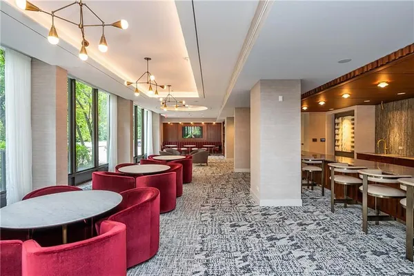 a large kitchen with sink a refrigerator and chairs
