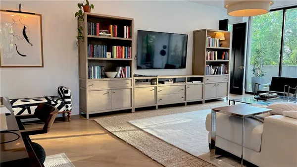 a living room with furniture a bookshelf and a large window