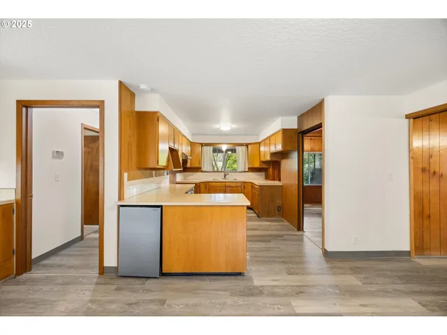 a kitchen with cabinets and wooden floor