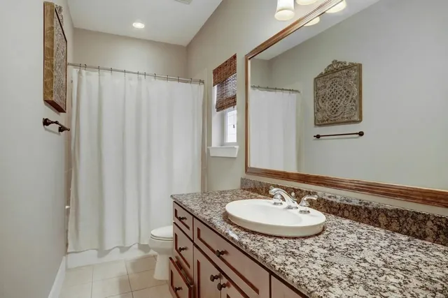 a bathroom with a granite countertop sink a mirror and a shower