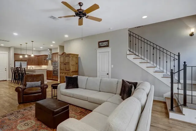 a living room with furniture kitchen view and a chandelier