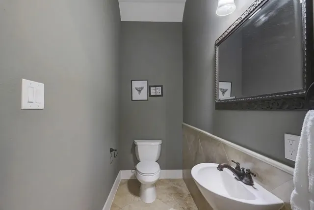 a bathroom with a toilet a sink and mirror