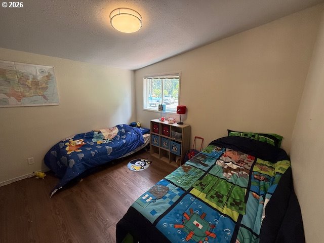 8429 Duncan Island Road Mapleton, OR 97453 - Photo 16 of 24 a bedroom with a bed and a wooden floor