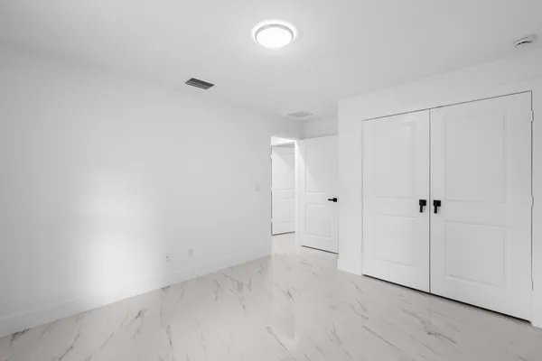 an empty room with windows and closet