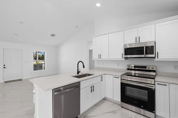 a kitchen with white cabinets and stainless steel appliances